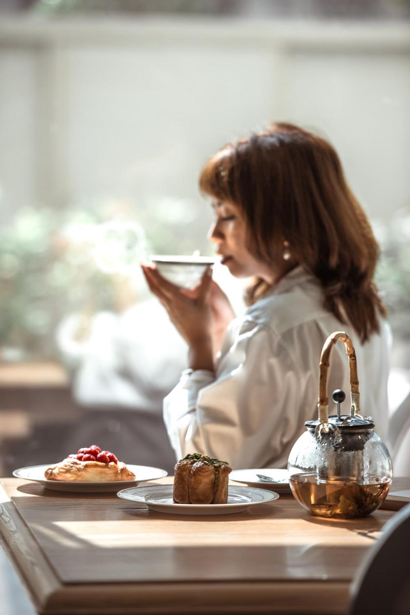 Dusit Doha Hotel Buitenkant foto A woman drinking tea